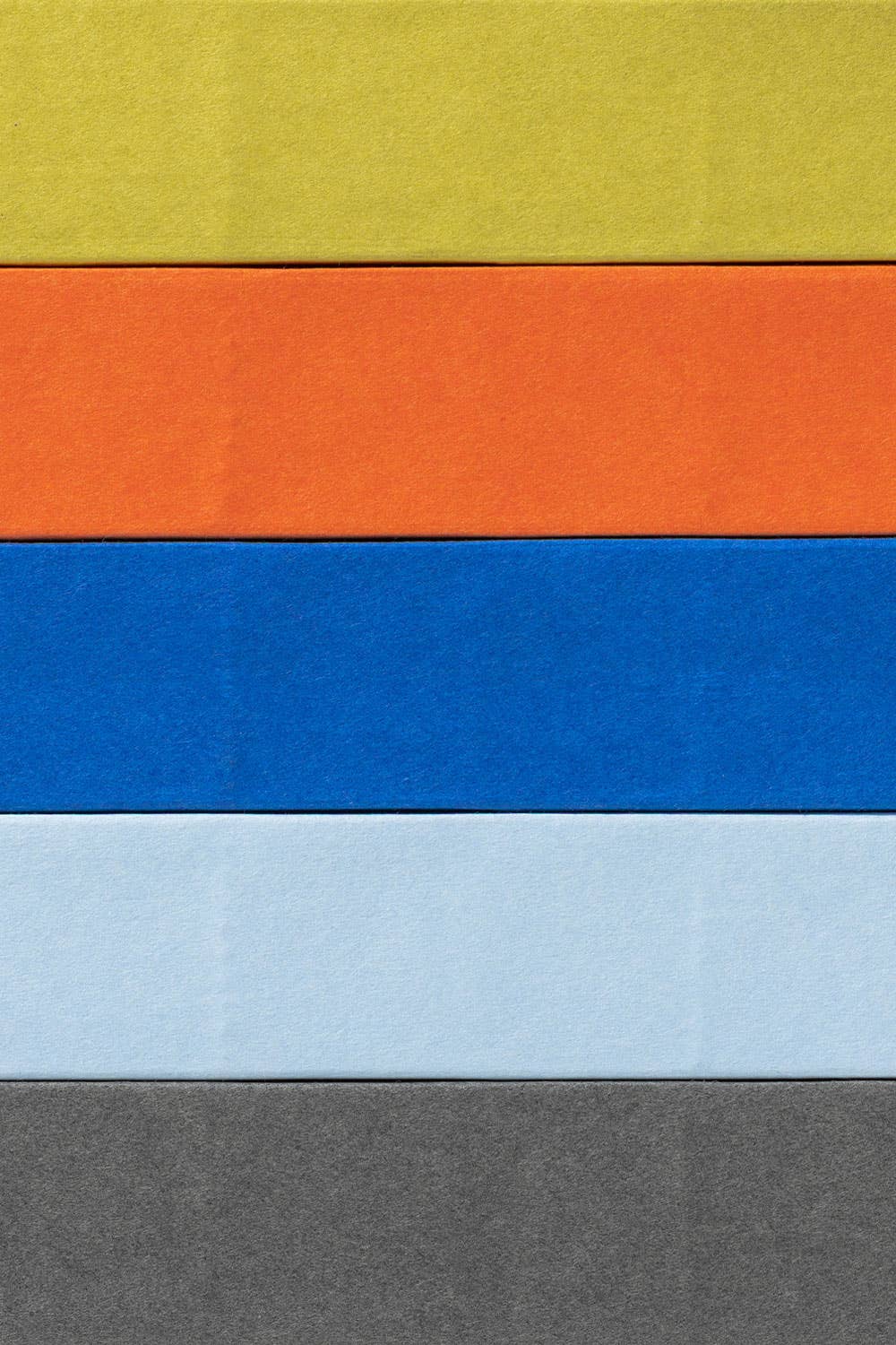 Gestapelde Naked-notitieboeken van mishmash in chartreuse, oranje, blauw en lichtblauw