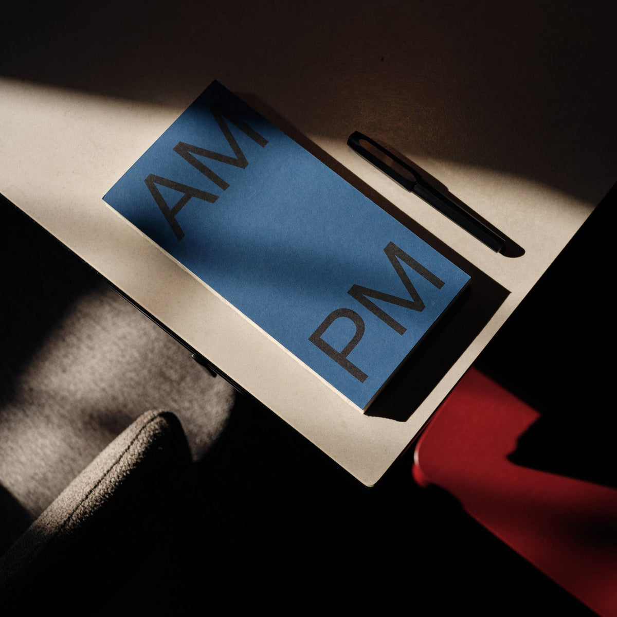 Dagplanner AM-PM Saffier van This Might Work op tafel met een pen, sfeerfoto