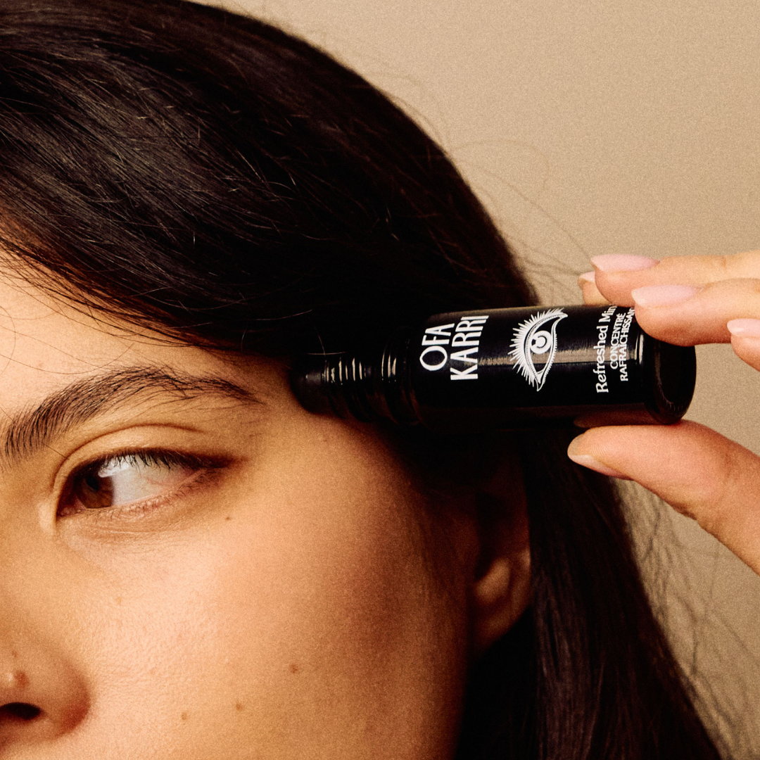 Vrouw brengt de Refreshed Mind roll-on van Ofa Karri aan op haar slaap