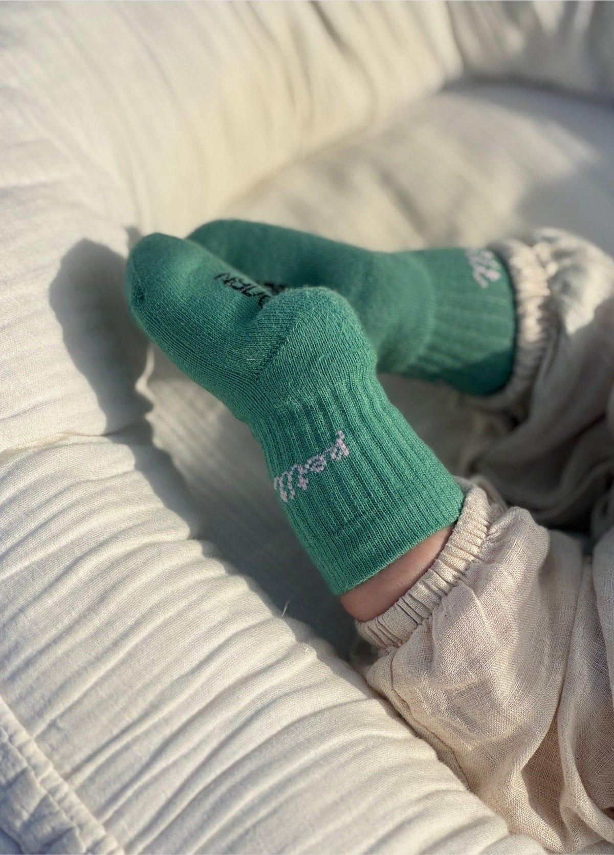 Babyvoetjes in groene babysokken Petit van No Bad Days Club