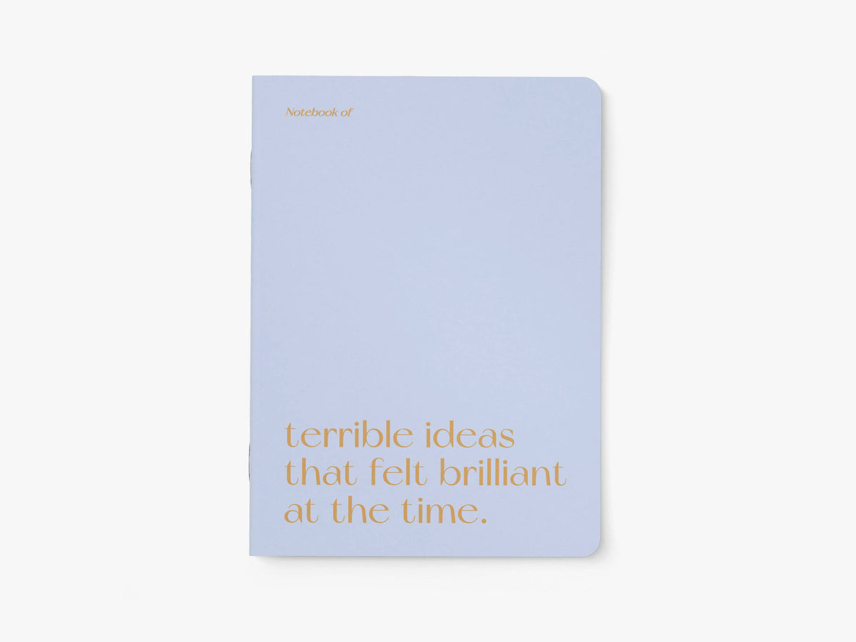 Notitieboek A5 van typealive, lichtblauw met oranje tekst 'terrible ideas that felt brilliant at the time.', vooraanzicht