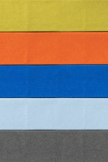 Gestapelde Naked-notitieboeken van mishmash in chartreuse, oranje, blauw en lichtblauw