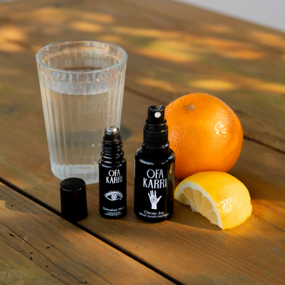 Citrusy Joy en Refreshed Mind van Ofa Karri op een houten tafel met een sinaasappel en een glas water