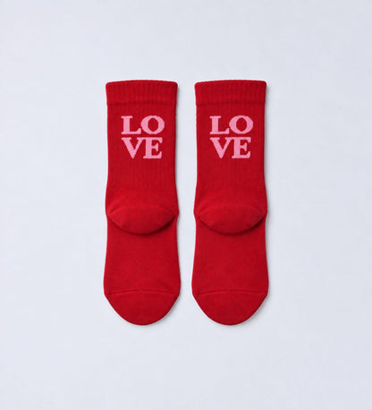 Paar rode babysokken Love van No Bad Days Club met roze opschrift, productfoto