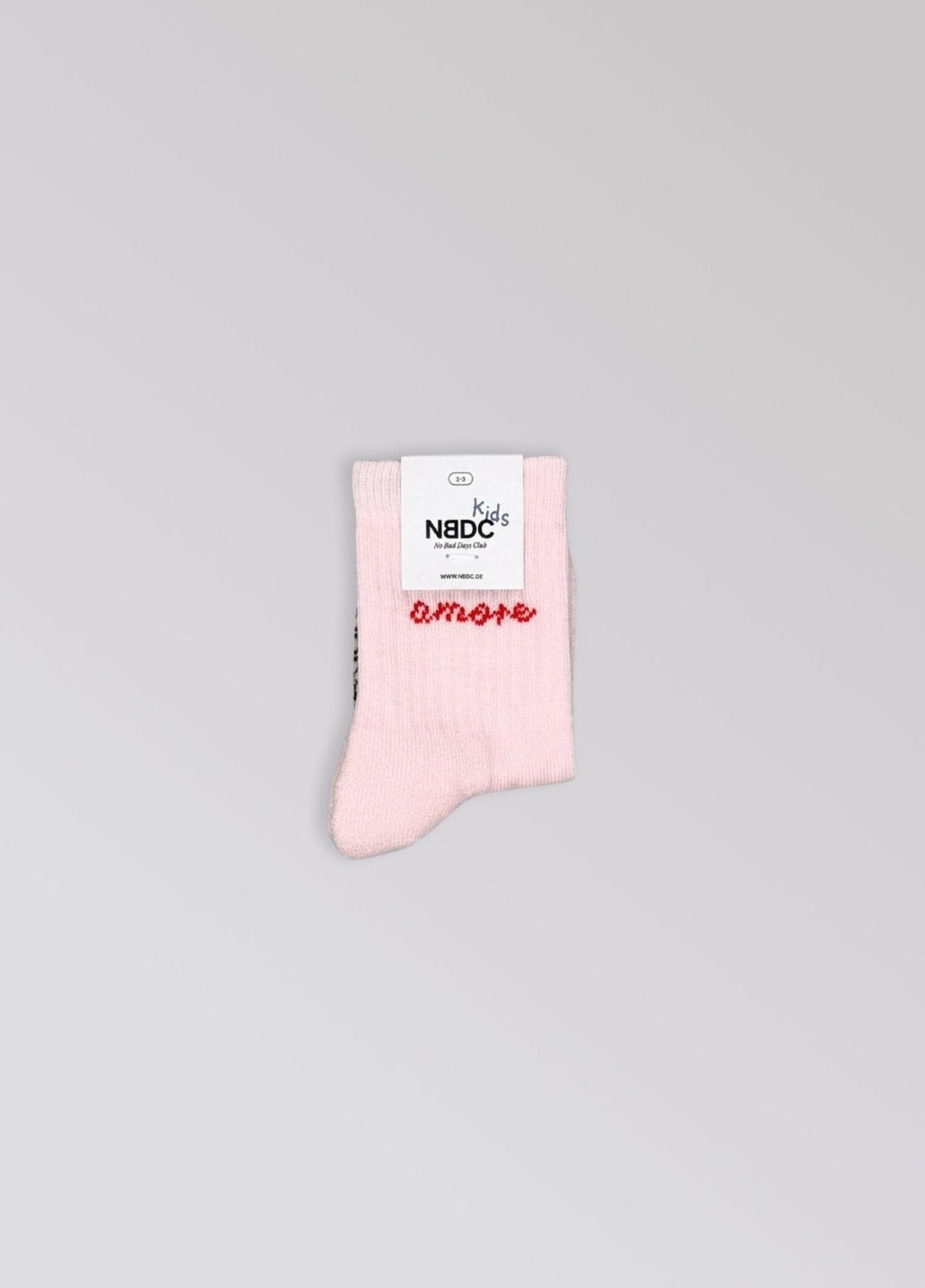 Babysok Amore van No Bad Days Club met NBDC-label, lichtroze met rood opschrift