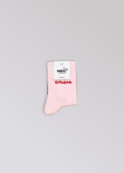Babysok Amore van No Bad Days Club met NBDC-label, lichtroze met rood opschrift